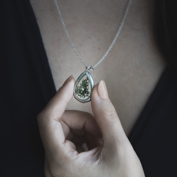 Reindeer moss sandwiched in between 1" panes of glass. Slips overhead with a 24" sterling silver chain that slips overhead.